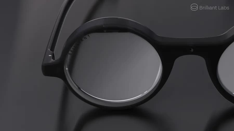 Brilliant Labs Frame glasses in black, close-up on the round lens with the word Brilliant engraved along the rim.