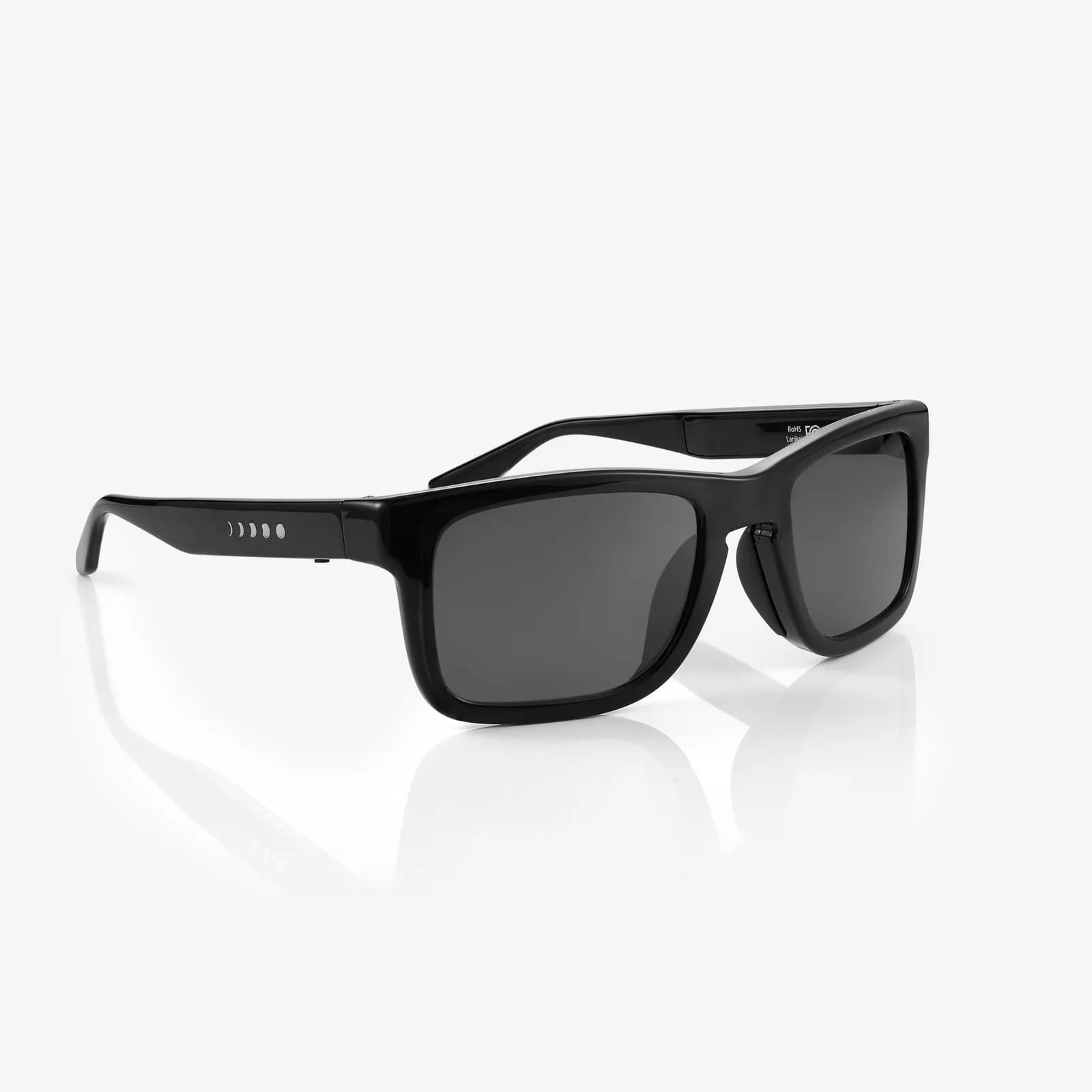 Gafas de sol inteligentes Chamelo Prime en negro, montura rectangular gruesa, en tres cuartos con puntos pequeños en la patilla.