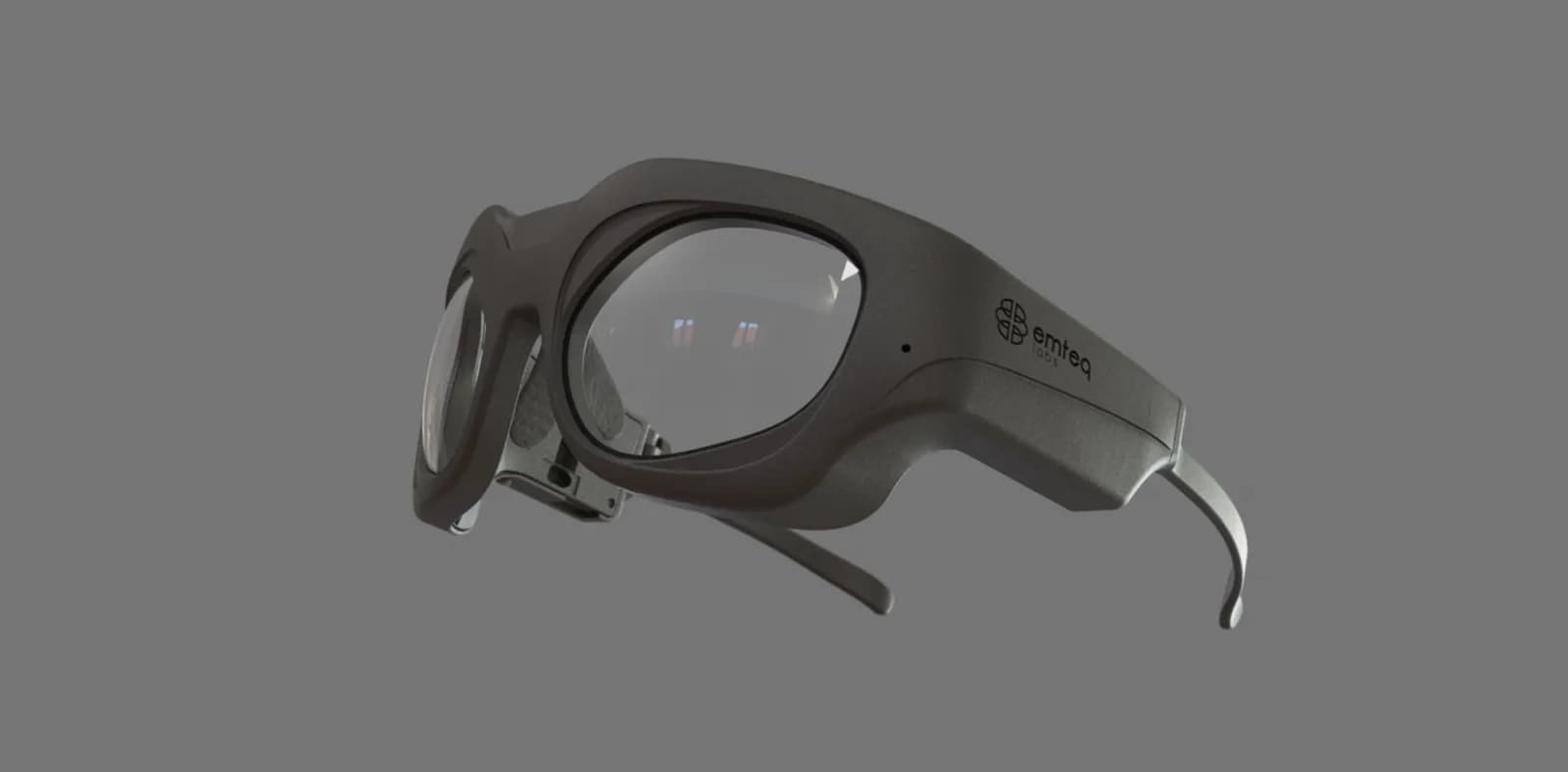 Emteq OCOsense visto de lado sobre fondo gris: montura gris gruesa con lentes transparentes, la marca emteq en la varilla derecha y las puntas de las varillas curvadas hacia abajo.