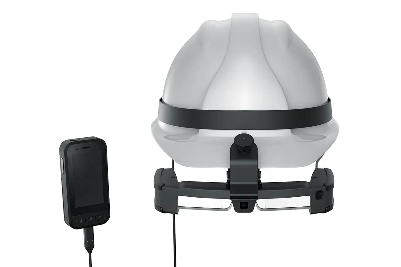 Epson Moverio BT-45C montado en un casco blanco, conectado por un cable a un controlador de mano negro al lado.