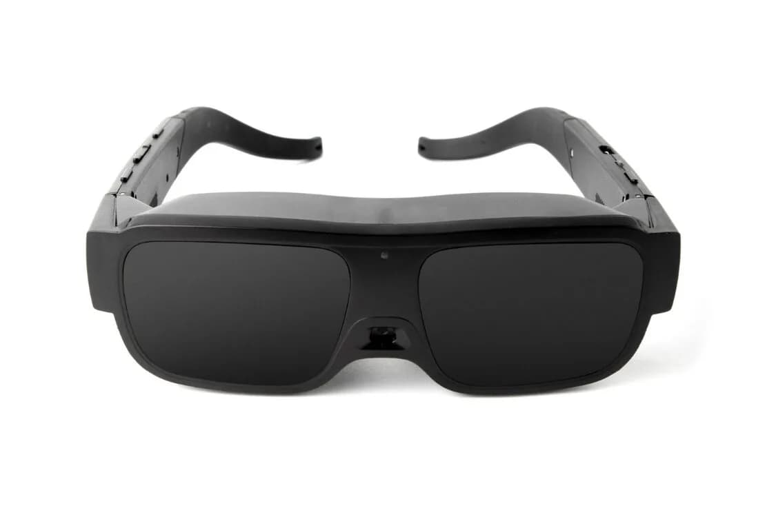eSight Go en negro, vista frontal del visor envolvente con una cámara pequeña entre las lentes opacas.