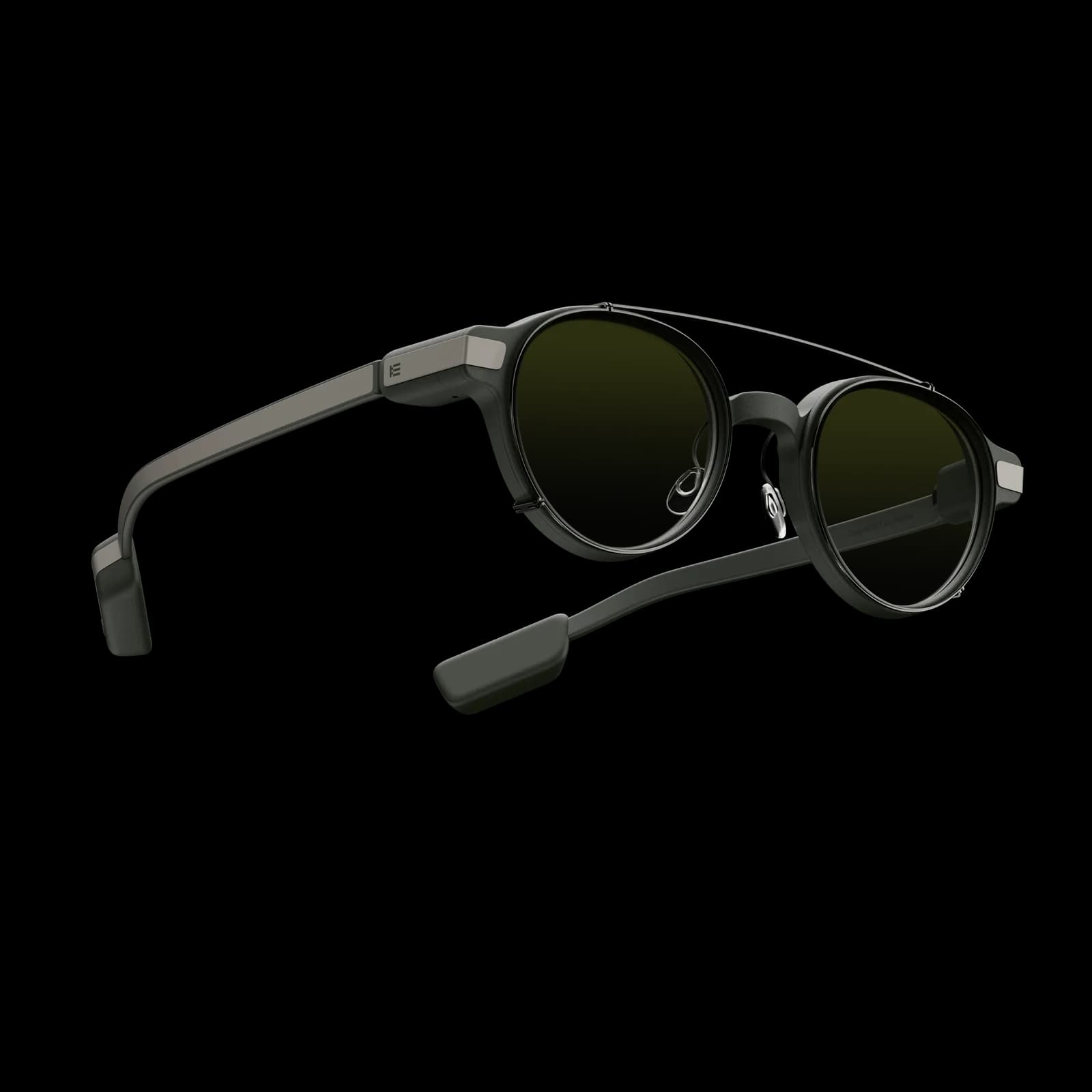 Gafas inteligentes Even Realities G1 con un clip de cristales oscuros encajado sobre los cristales redondos, plegadas en ángulo sobre fondo negro.