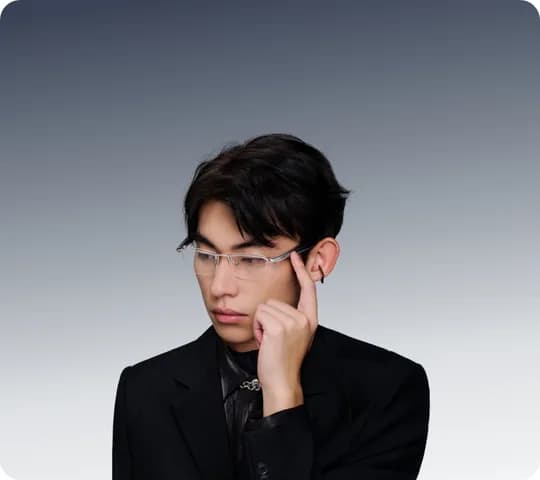 Gafas HUAWEI Eyewear 2 puestas por un joven de traje negro, montura fina al aire, tocando la patilla con un dedo, fondo oscuro de estudio.