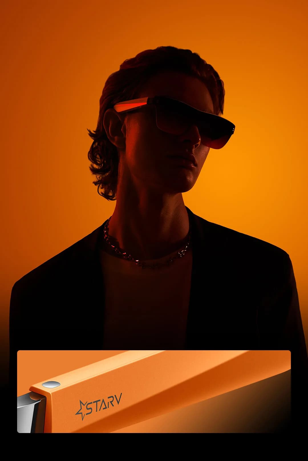 Gafas Meizu StarV View en negro en el rostro de un joven, de perfil con la patilla iluminada en naranja sobre fondo naranja.