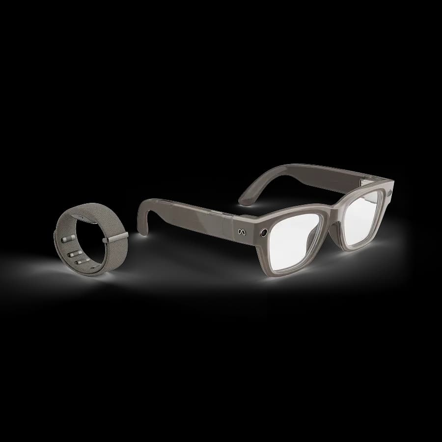 Gafas Meta Ray-Ban Display en gris junto a la Meta Neural Band, una pulsera de malla con contactos metálicos, en fondo blanco.