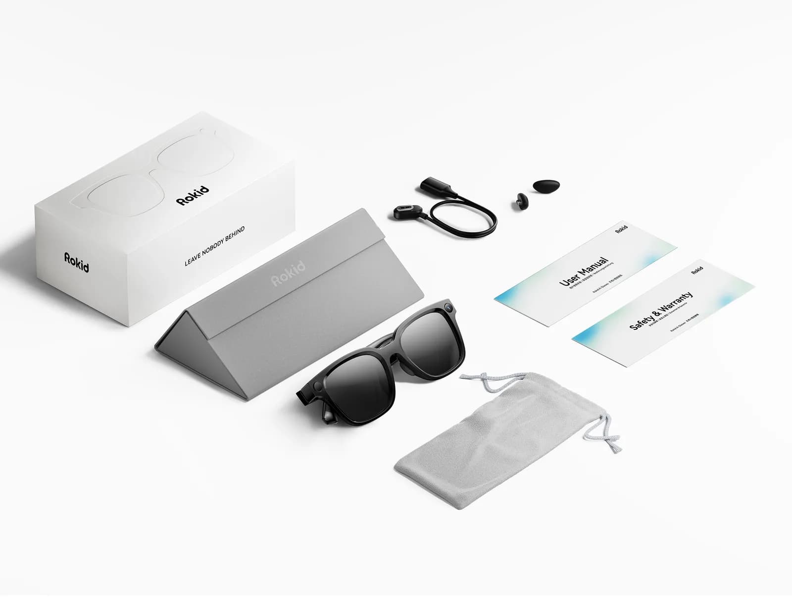 Rokid AI Glasses Style laid out with its white box, gray triangular case, charging cable, two ear tips, manual cards and a gray pouch.