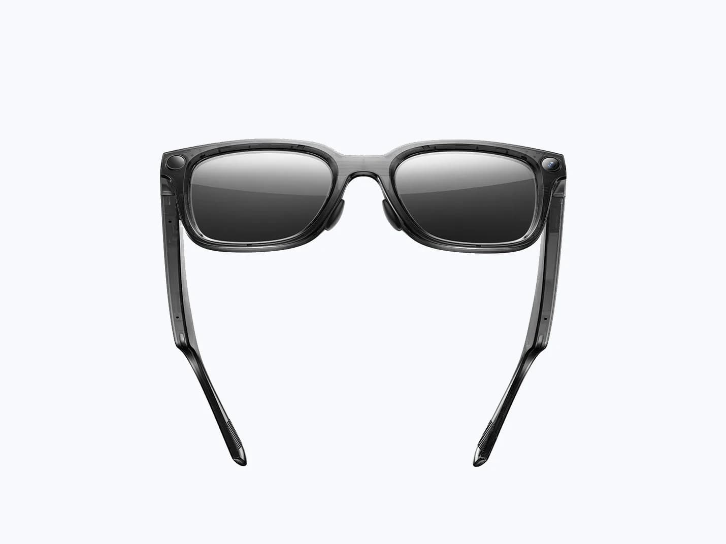 Rokid AI Glasses Style in translucent gray, seen from the front, with a round camera lens at each outer top corner of the frame.
