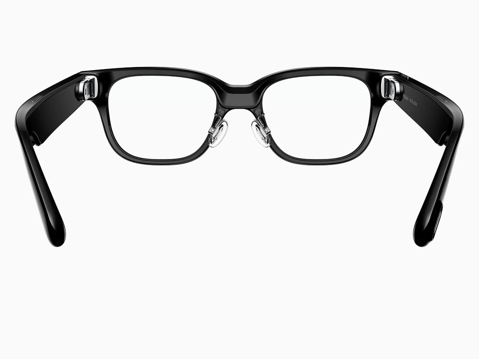 The Rokid Glasses RV101 seen from behind with the temples open: at the inner end of each temple sits the small prism that projects the green display into the eye, and the right temple carries the words Rokid and BOLON.