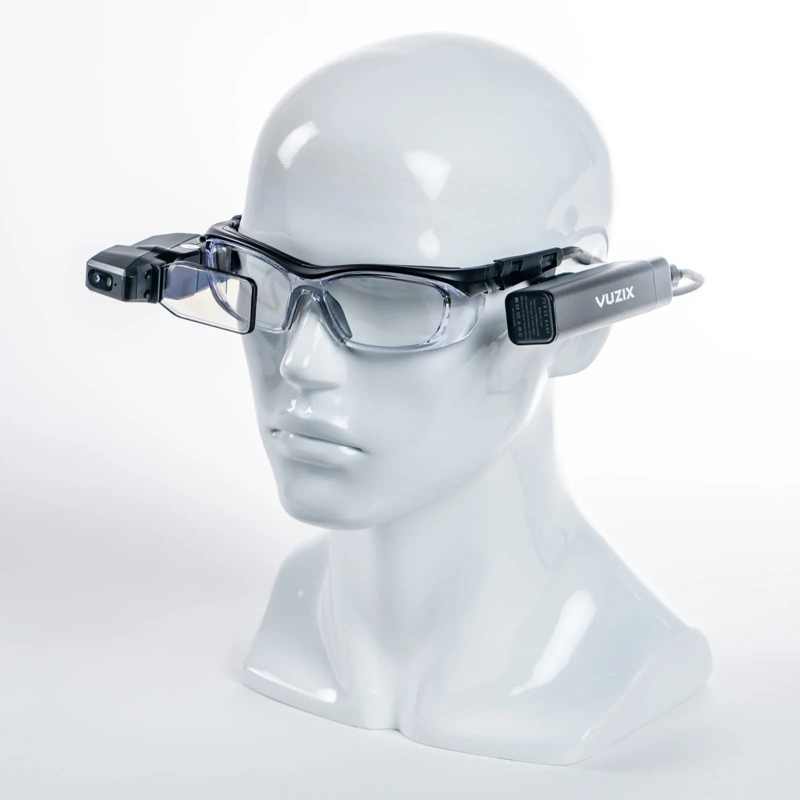 Vuzix M4000 on a white mannequin head, seen at an angle: safety glasses with the black display module on the right side and the battery on the left temple.