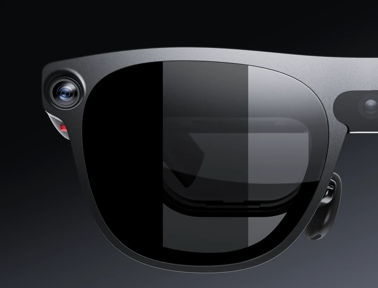 Close-up of a XREAL Aura lens, dark gray frame, with one side of the lens tinted darker than the other and a camera in the corner.