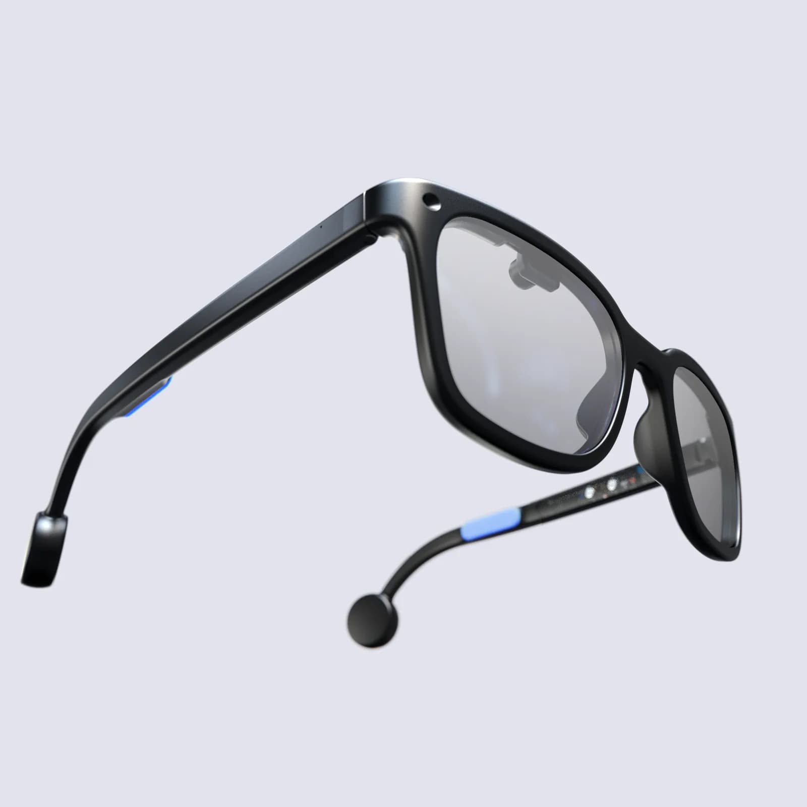 Brilliant Labs Halo in black, angled view, with a thick square frame, a lit blue stripe on the temple and a round tip module.