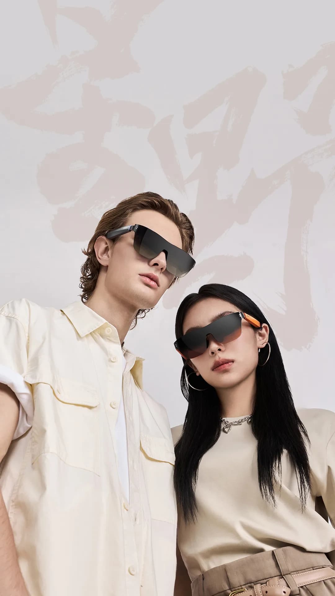 Meizu StarV View glasses in black on a man and a woman, wraparound shield lenses with an orange temple accent.