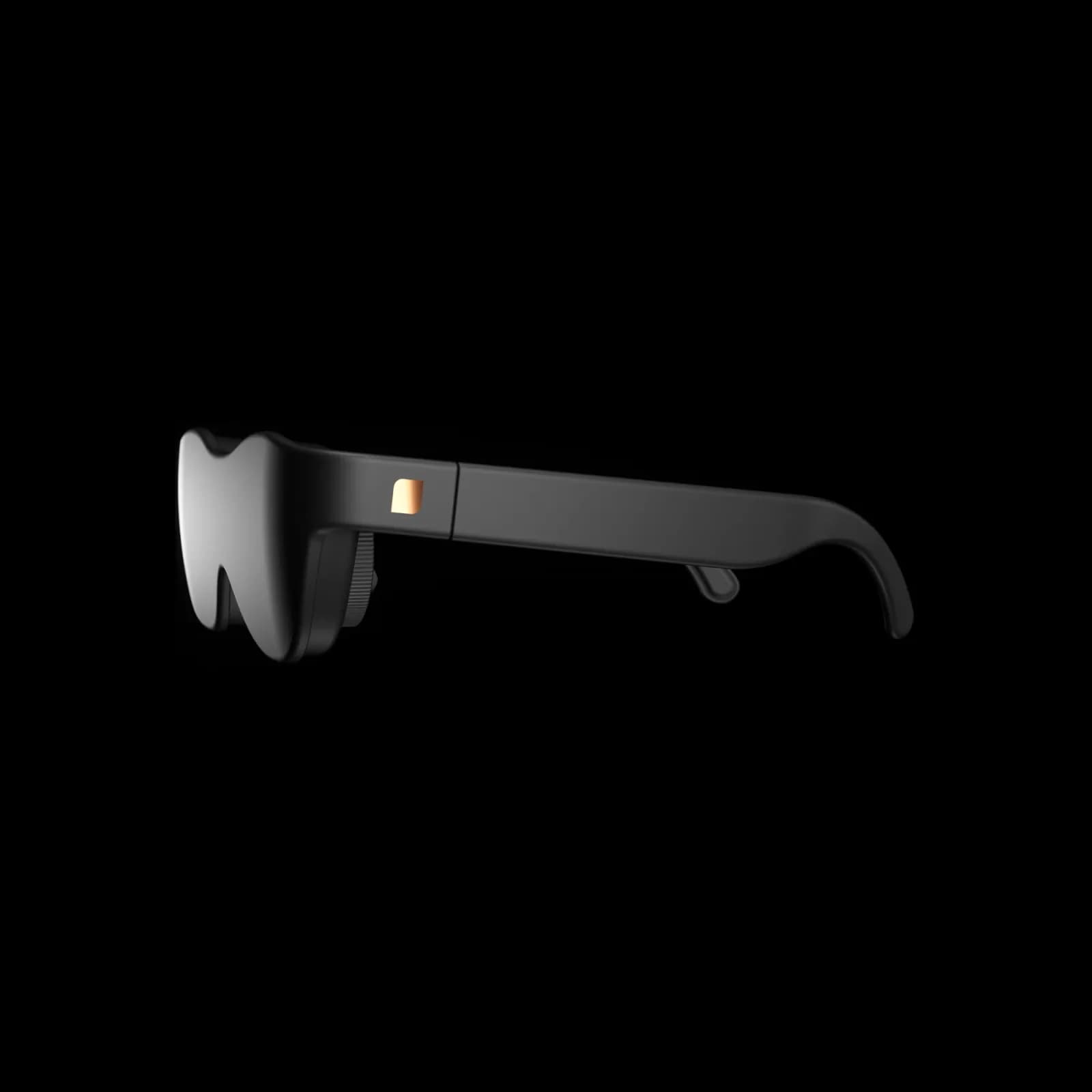 Sol Reader glasses in profile, black frame with a scroll wheel and a small gold accent on the temple, against a black background.