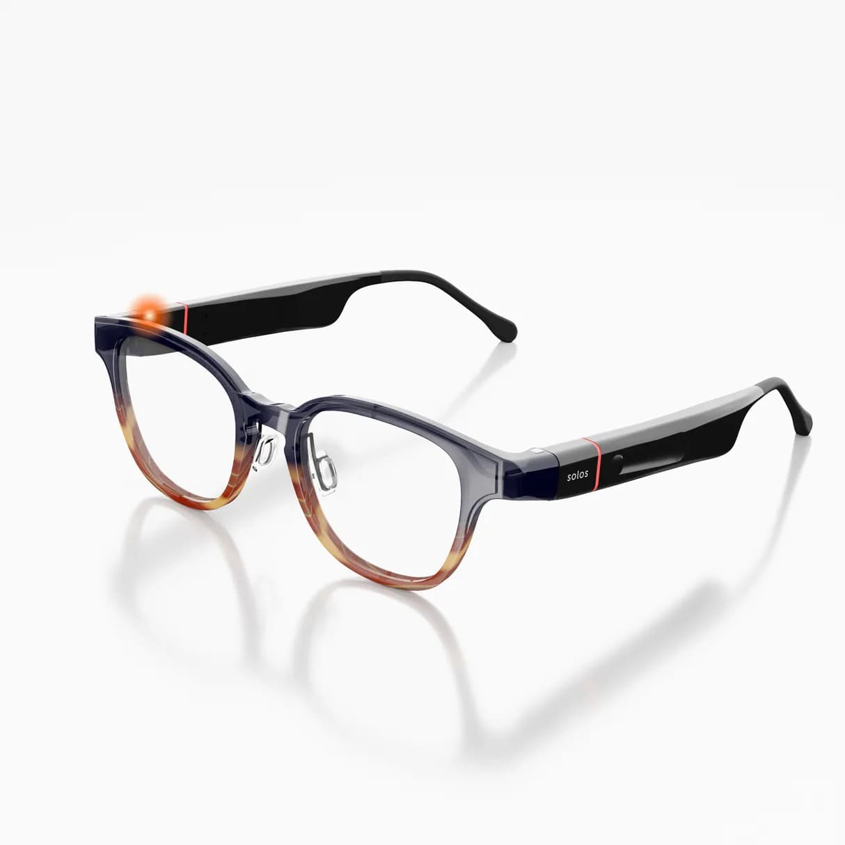 Solos AirGo 3 audio glasses with a round frame fading from gray to amber at the bottom, clear lenses, and a black temple with a red accent line.