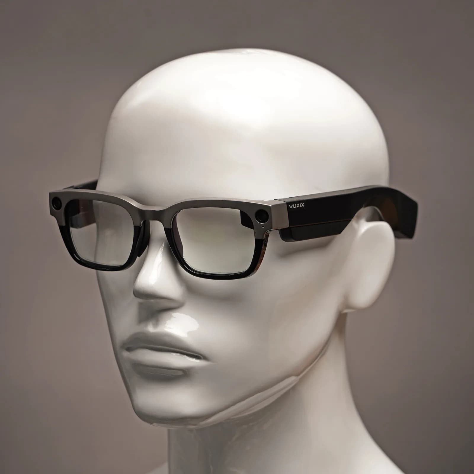 Vuzix Shield on a mannequin head, seen from the front, with a titanium top rim and a camera near each hinge.
