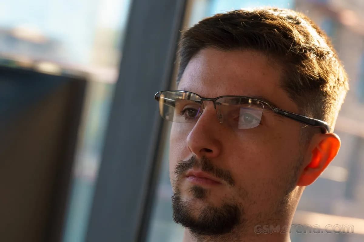 Xiaomi MIJIA Smart Audio Glasses worn by a man, half-rim metal frame with a black temple, seen close from the side.
